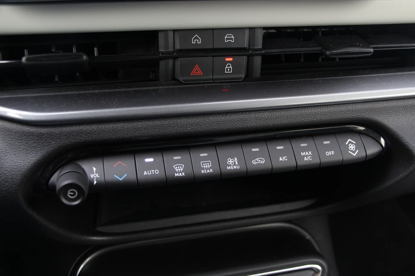 Panel sterowania klimatyzacją w samochodzie z widocznymi przyciskami do regulacji temperatury, nawiewu oraz innych funkcji komfortowych, takich jak ogrzewanie, wentylacja i klimatyzacja.