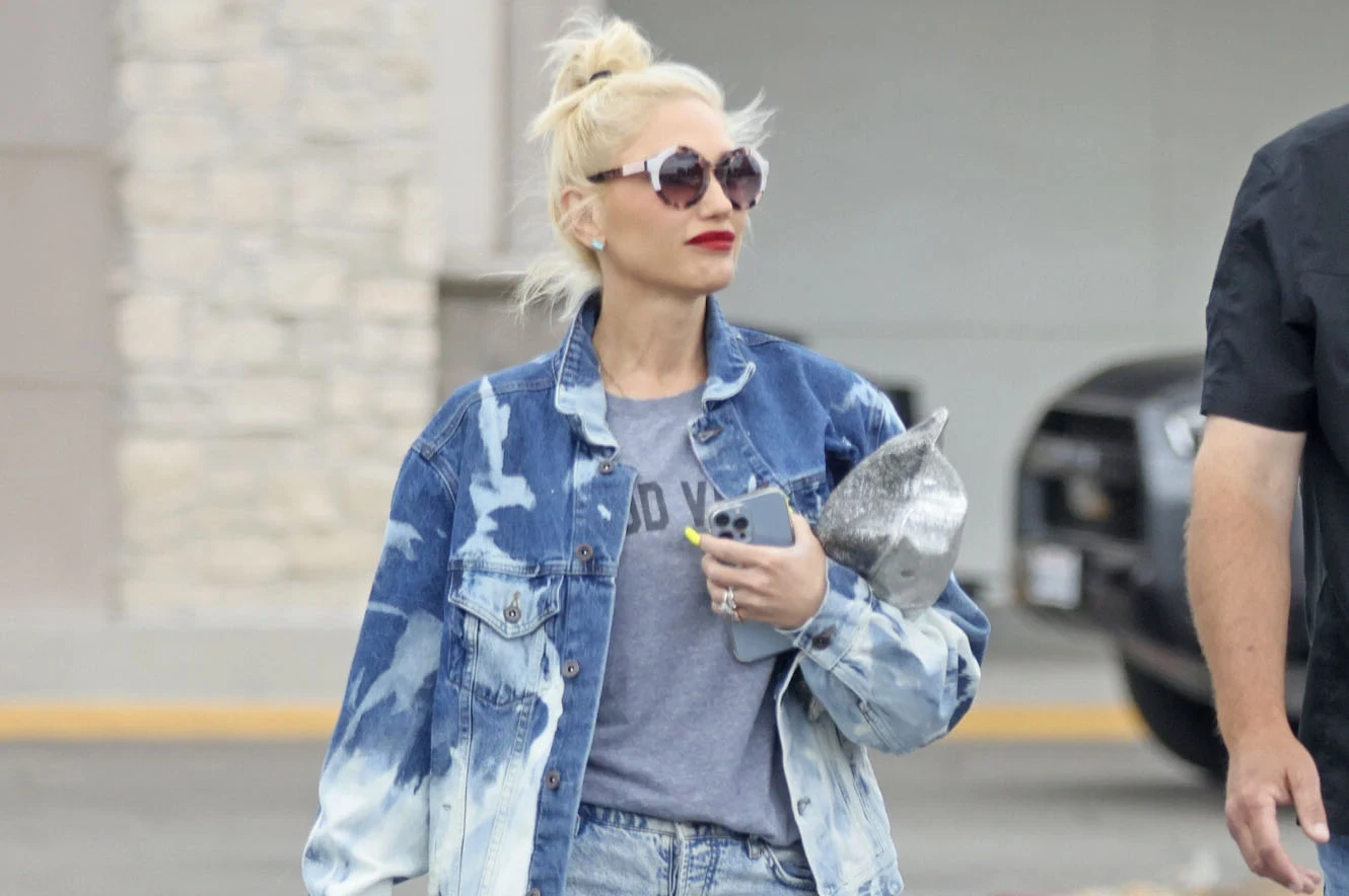 Gwen Stefani nie boi się odważnych stylizacji Kobieta o blond włosach spaceruje ubrana w szary t-shirt i dżinsową kurtkę