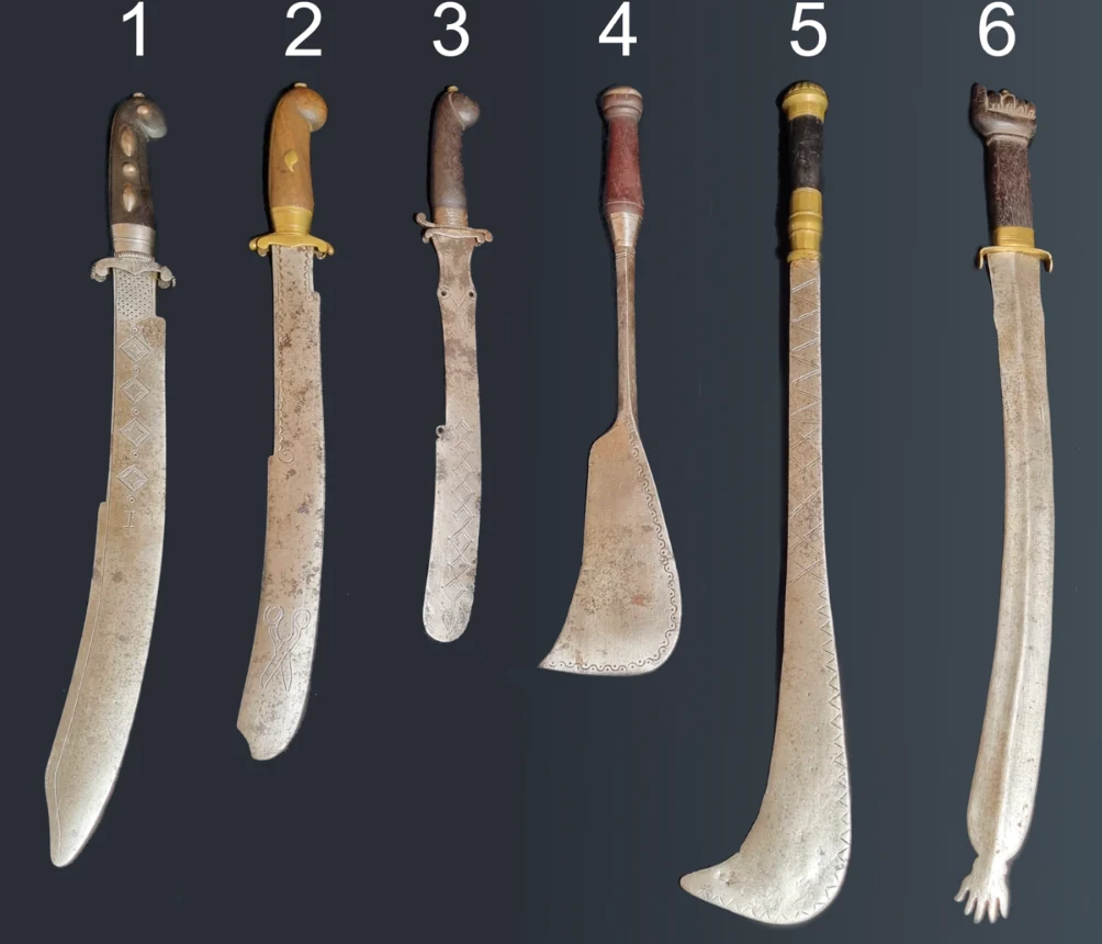 Miecze poddano nieinwazyjnym, nowoczesnym metodom badawczym. Niezwykła broń z Dahomeju okazała się bardziej fascynująca, niż wcześniej zakładano. Sześć różnych typów maczet na ciemnym tle, każda z numerem od 1 do 6 powyżej ostrza. Rękojeści mają różnorodne wykończenia i materiały, co podkreśla różnorodność w stylu i funkcji tych narzędzi.