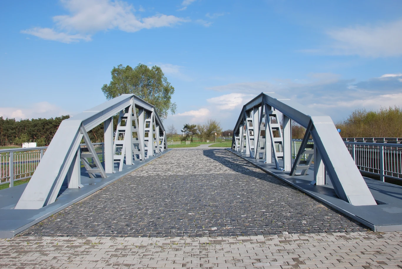 Most w Maurzycach nieopodal Łowicza jest wyłączony z ruchu dla pojazdów. Można go jednak zwiedzać pieszo. Stalowy most o nowoczesnej konstrukcji rozciągający się nad brukowaną drogą w otoczeniu bujnej zieleni i błękitnego nieba.