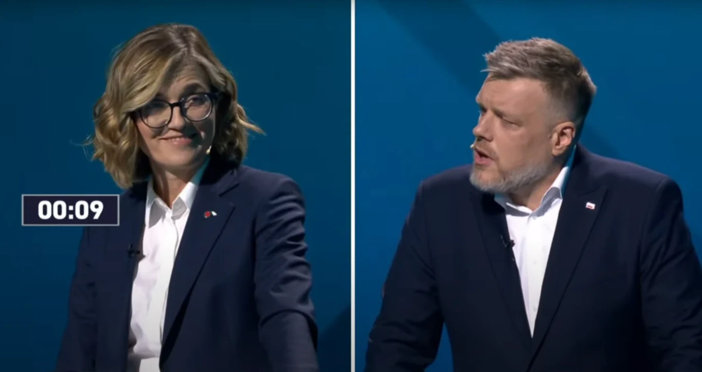 Dyskusja podczas debaty prezydenckiej między Magdaleną Biejat a Adrianem Zandbergiem Dwoje mówców stoi obok siebie na tle niebieskiej ściany, ubrani w formalne stroje. Na zdjęciu widoczny jest licznik wskazujący czas, co sugeruje debatę lub dyskusję publiczną.