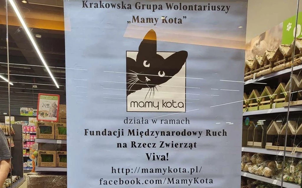 Zbiórka karmy w krakowskim sklepie zoologicznym Plakat informacyjny o działaniach Krakowskiej Grupy Wolontariuszy 'Mamy Kota', działającej w ramach Fundacji Międzynarodowy Ruch na Rzecz Zwierząt Viva!, umieszczony na przeszklonych drzwiach.