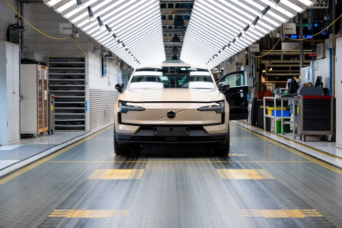 Przystosowanie fabryki w Gandawie do produkcji EX30 kosztowało Volvo 200 mln euro. Nowoczesny samochód na linii montażowej w fabryce, dobrze oświetlona hala produkcyjna z maszynami i narzędziami po bokach.