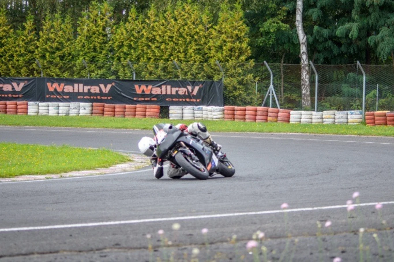 Przeciwskręt nie jest techniką zarezerwowaną dla wyścigów motocyklowych czy żużla. Motocyklista w kasku pochylony na motocyklu podczas zakrętu na torze wyścigowym otoczonym zielenią i bandami ochronnymi.