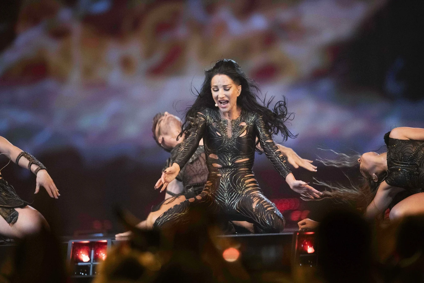 Justyna Steczkowska zaprezentuje "Gaję" podczas Polsat Hit Festiwal 2025 Grupa tancerzy wykonuje energiczny występ sceniczny z udziałem głównej tancerki ubranej w ozdobny strój. W tle dynamiczne efekty świetlne, które podkreślają dynamiczny charakter pokazu.