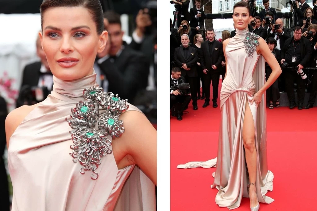 Cannes 2025: Isabella Fontana wyróżniła się kreacją Isabella Fontana w eleganckiej sukni na czerwonym dywanie, z dużą, błyszczącą ozdobą na ramieniu. W tle widać tłum ludzi, w tym fotografów. Suknia ma długi rozporek, co dodaje jej szyku.