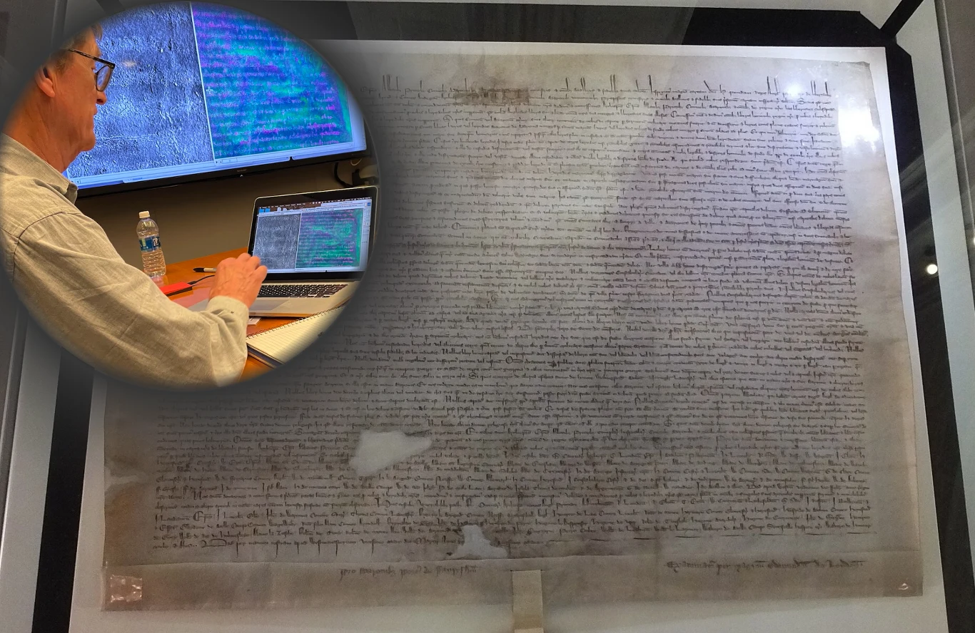 Naukowcy udowodnili, że rzekoma kopia słynnego dokumentu Magna Carta jest wartym miliony oryginałem. Stara, ręcznie napisana karta dokumentu umieszczona w gablocie wystawowej. Na powierzchni widać wyjątkową kaligrafię i strukturę tekstu. W załączeniu małe zdjęcie mężczyzny pracującego przy laptopie z ekranem wyświetlającym skan dokumentu.