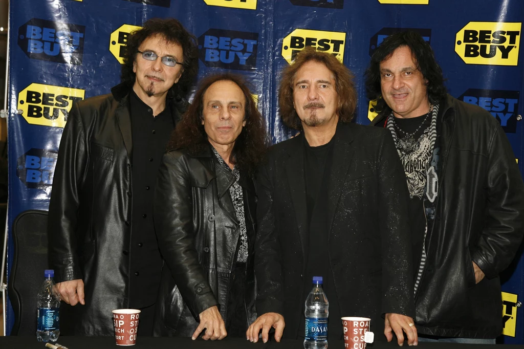 Heaven & Hell w 2007 r. - od lewej: Tony Iommi, Ronnie James Dio, Geezer Butler i Vinny Appice Czterech osób stoi przed tłem z logo Best Buy, ubranych w ciemne skórzane kurtki, prezentując charakterystyczny rockowy styl.