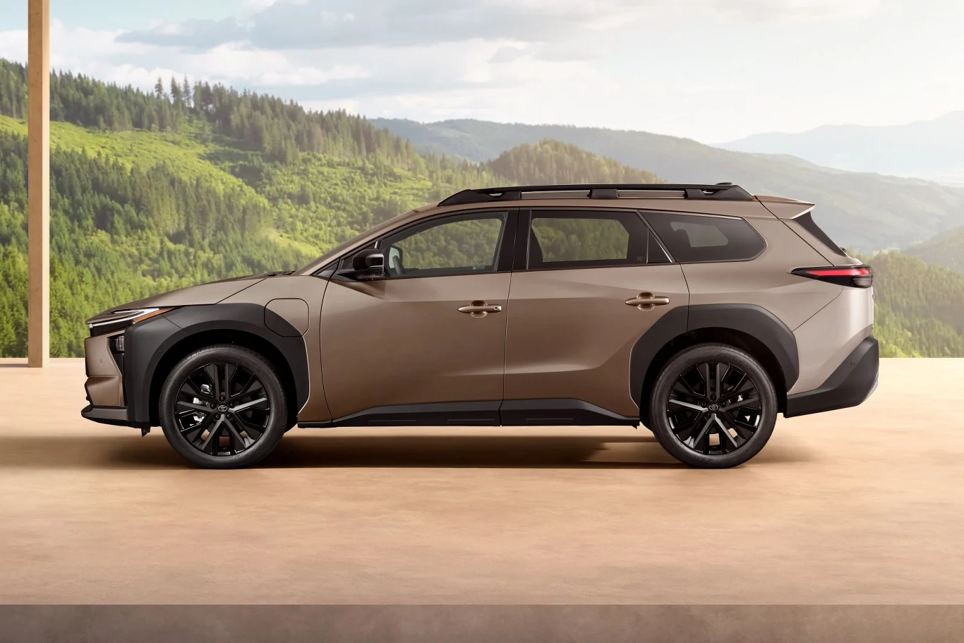 Nowoczesny SUV w kolorze brązowym, zaparkowany na tle malowniczych gór i lasów, ukazujący elegancję i innowacyjność motoryzacyjną.