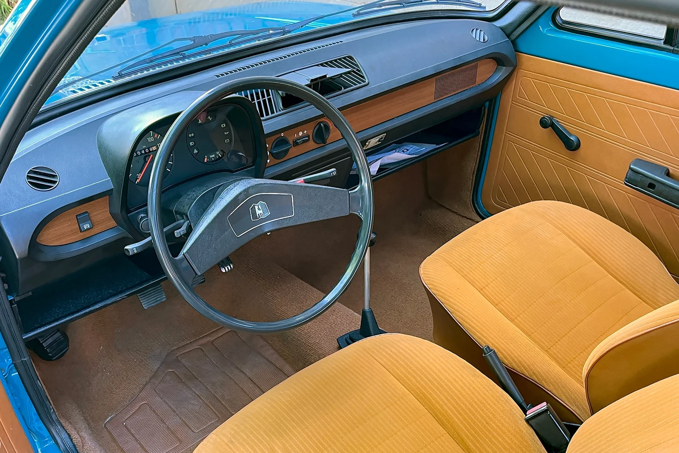 We wnętrzu uwagę przyciągały fotele obszyte tapicerką wysokiej jakości. Wnętrze klasycznego samochodu z lat 70., z brązowymi siedzeniami i retro deską rozdzielczą. Kierownica, zegary i elementy tapicerki zachowane w oryginalnym stylu, charakterystyczne dla tego okresu.