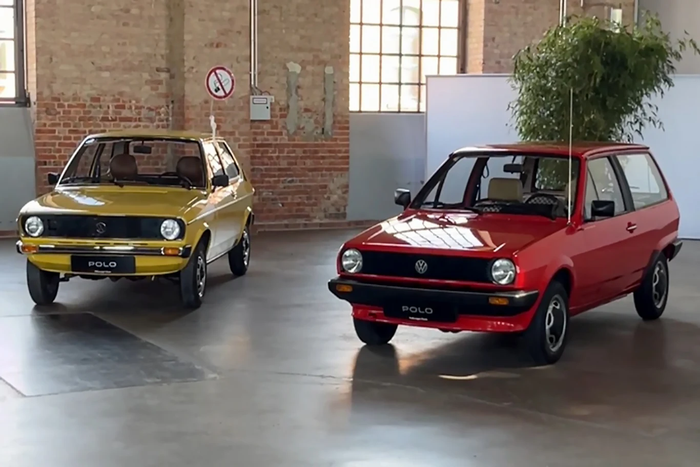 Volkswagen Polo II (po prawej) przybrał formę dwudrzwiowego, małego kombi. Dwa klasyczne modele samochodów Volkswagen Polo, jeden w kolorze czerwonym, drugi żółtym, ustawione w przestronnej hali z widocznymi ceglastymi ścianami.