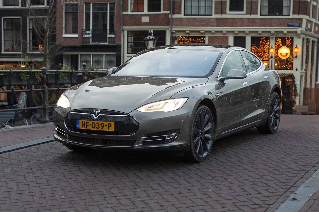 Holendrzy nie boją się elektryków. Tesle służą m.in. w drogówce Samochód Tesla Model S zaparkowany na tle miejskiej zabudowy, widoczne oświetlenie miejskie oraz ceglane budynki w tle.