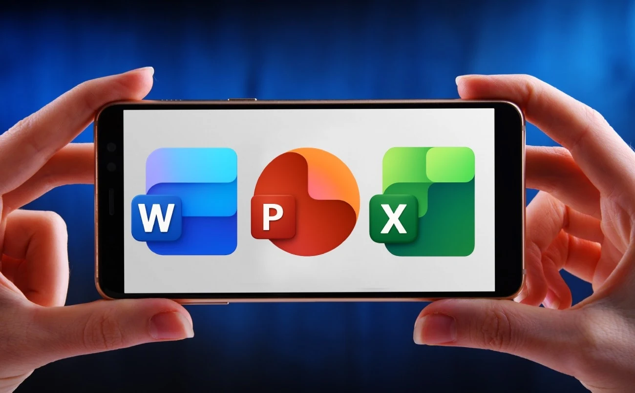 Microsoft testuje nowe ikony Office. Sztuczna inteligencja je powiększyła Smartfon trzymany przez dwie ręce wyświetla trzy ikony aplikacji biurowych: W, P oraz X na ekranie, symbolizujące programy do edycji tekstu, prezentacji oraz arkuszy kalkulacyjnych.