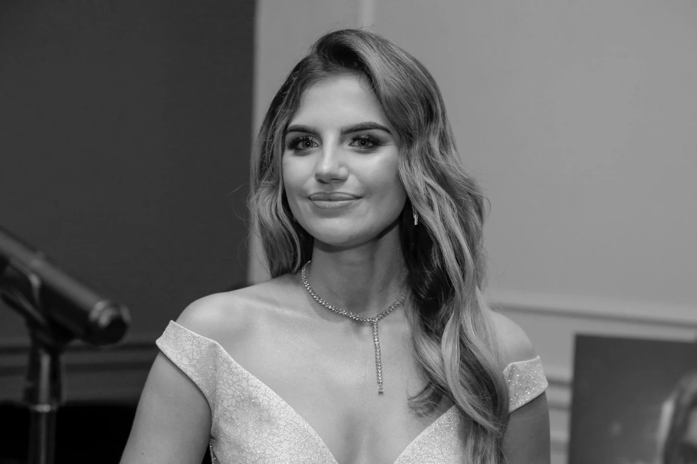 Sonia Szklanowska zmarła w wieku 25 lat Kobieta w eleganckiej sukience z uśmiechem na twarzy stoi na tle mikrofonu i ściany. Jej długie, falujące włosy są rozpuszczone, a na szyi ma delikatny naszyjnik.