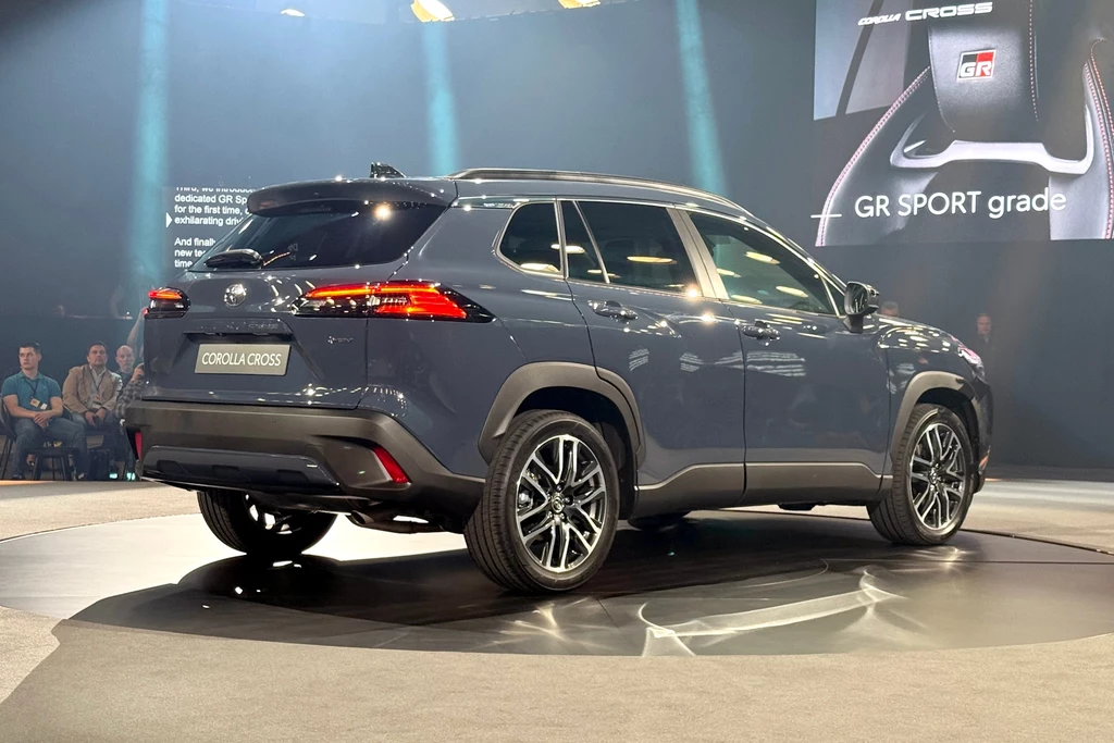 Samochód Toyota Corolla Cross w wersji GR SPORT prezentowany na obrotowej scenie podczas targów motoryzacyjnych. Nowoczesne reflektory i eleganckie linie nadwozia podkreślają sportowy charakter pojazdu.