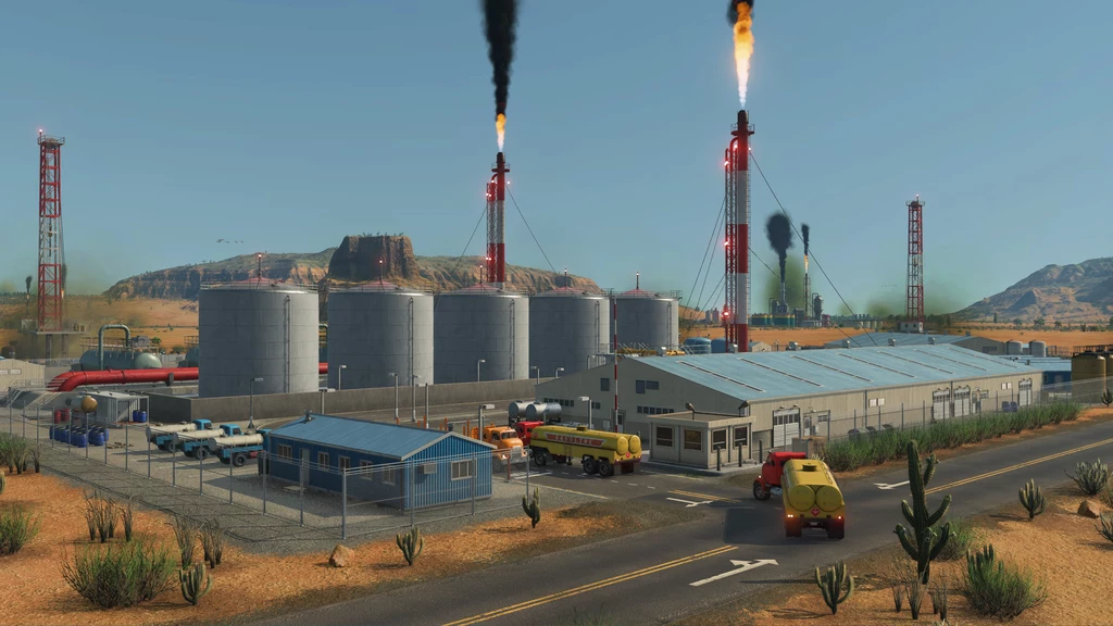 Transport Fever 3 - screen z gry Zakład przemysłowy na pustynnym terenie z kilkoma dużymi silosami, pojazdami serwisowymi i płomieniami wydobywającymi się z kominów, otoczony ogrodzeniem i roślinnością charakterystyczną dla suchych regionów.