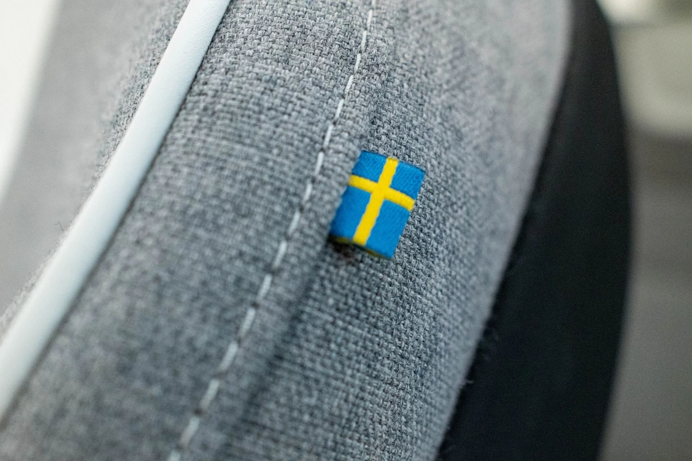 Szara tkanina z naszywką w postaci małej flagi Szwecji z żółtym krzyżem na niebieskim tle.