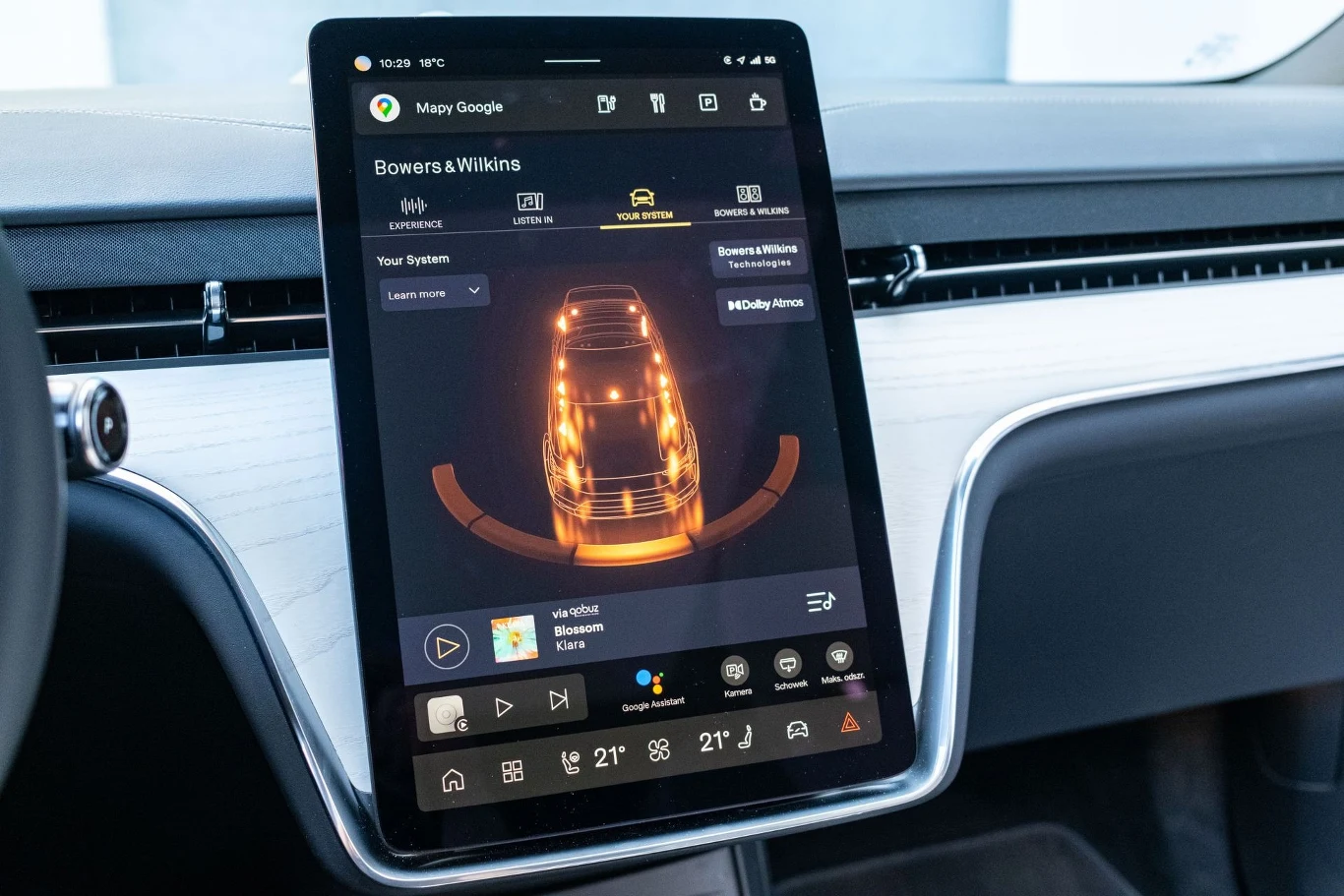 Duży ekran dotykowy w samochodzie wyświetlający interfejs systemu multimedialnego z wizualizacją pojazdu, opcjami sterowania dźwiękiem oraz ustawieniami komfortu i klimatyzacji.