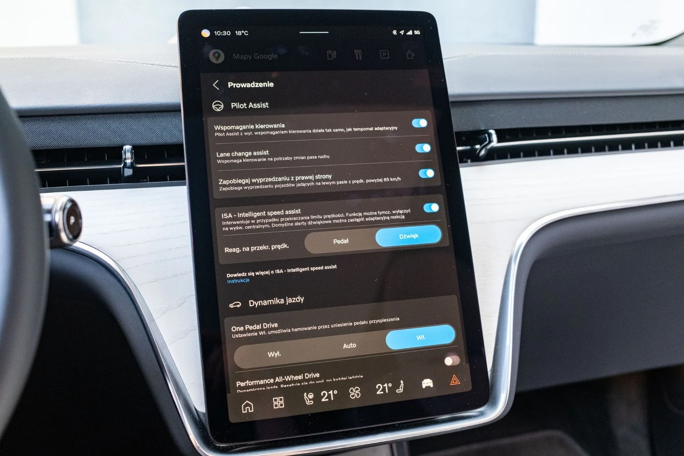 elegancki, duży ekran dotykowy na konsoli środkowej samochodu z menu ustawień asystenta jazdy oraz klimatyzacji, otoczony jasnym wnętrzem z nowoczesnym wykończeniem