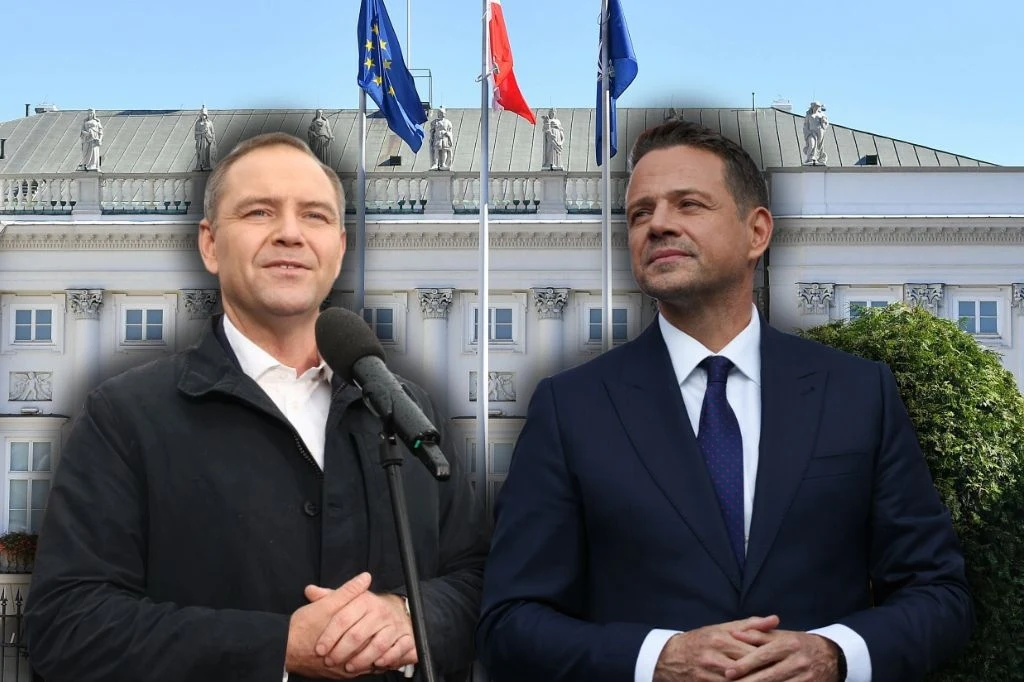 Wybory prezydenckie. Kto wygra w II turze? Pierwszy taki sondaż Dwóch mężczyzn w garniturach stoi na tle budynku rządowego z trzema flagami na masztach, w tym flagą Polski i Unii Europejskiej, w tle błękitne niebo.