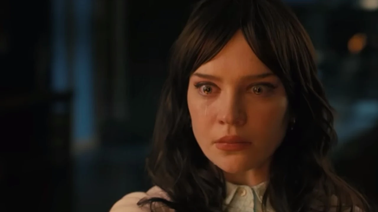 Zwykły człowiek zmienił AI. Tak zaczyna się koniec kontroli Młoda kobieta o ciemnych włosach z wyrazem smutku i łzami w oczach, na tle ciemnego, rozmytego wnętrza.