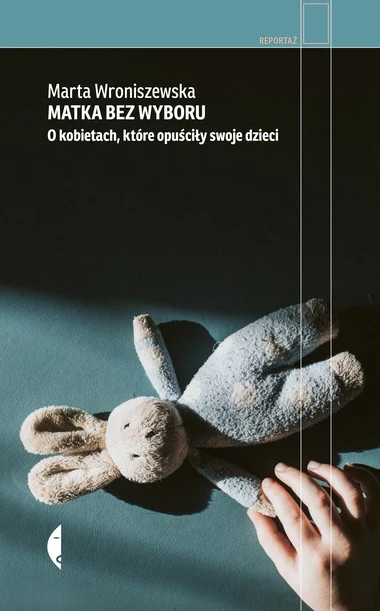 Pluszowy królik leży na niebieskiej powierzchni, obok znajduje się dłoń dziecka sięgająca do zabawki. W górnej części widoczny jest tytuł książki oraz nazwisko autorki.