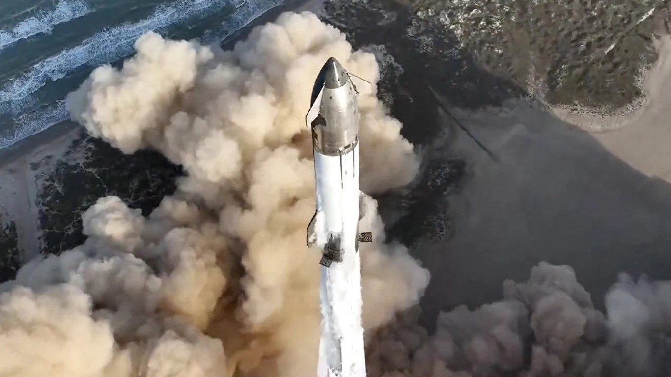 Wielki sukces Starshipa. Jest gotowy do lotu na Księżyc i Marsa Start rakiety kosmicznej unoszącej się nad ziemią z dużą ilością dymu i pyłu, w tle linia brzegowa oraz fale oceanu.