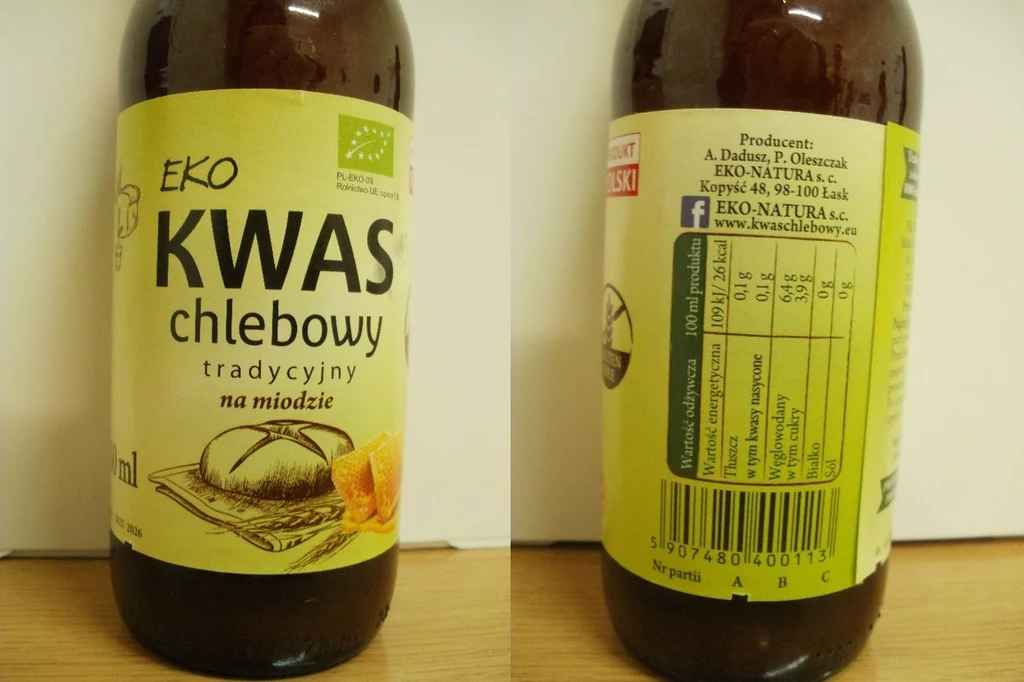 Butelka tradycyjnego kwasu chlebowego z miodem o nazwie EKO, z widoczną etykietą zawierającą nazwę produktu, opis, wartości odżywcze oraz dane producenta.