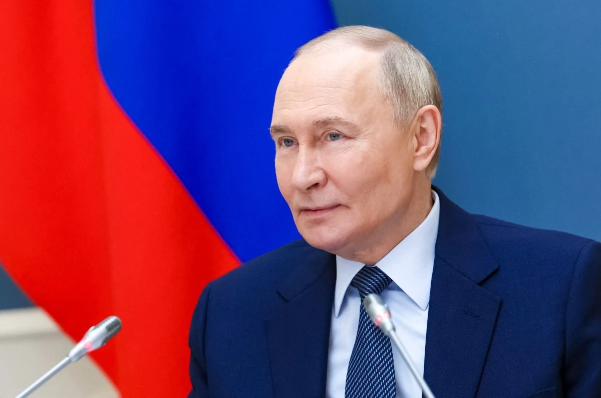 Putin może liczyć na gwarancję ze strony Trumpa. Warunkiem pokój w Ukrainie Mężczyzna w garniturze siedzący przy stole z mikrofonami, w tle widoczna duża flaga w barwach czerwono-niebiesko-białych.