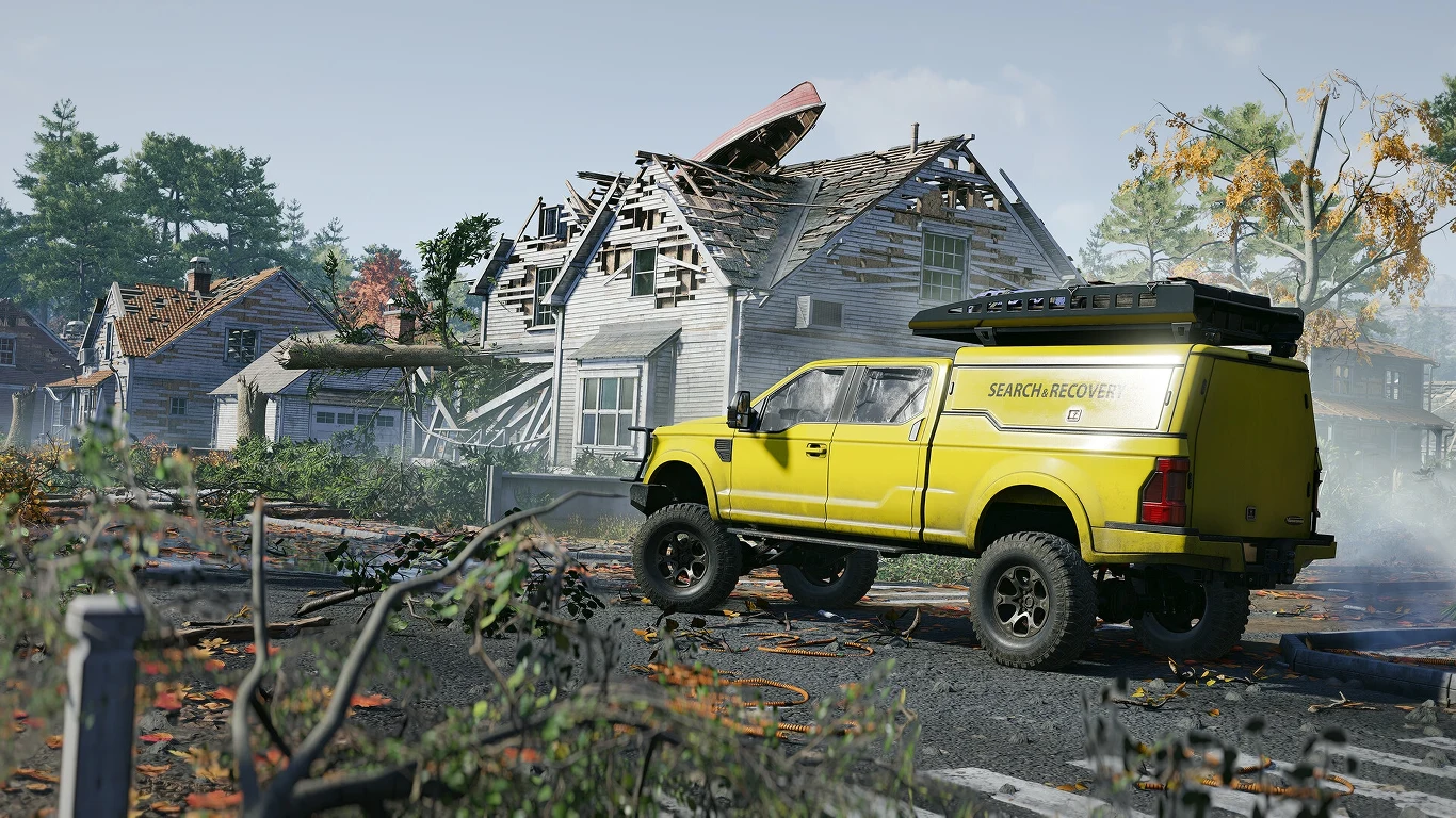 RoadCraft Jasnożółty pojazd poszukiwawczo-ratowniczy stoi na drodze wśród zniszczonych domów, częściowo zawalonych dachów i powalonych drzew, w otoczeniu widać ślady zniszczeń oraz gałęzie na ziemi.
