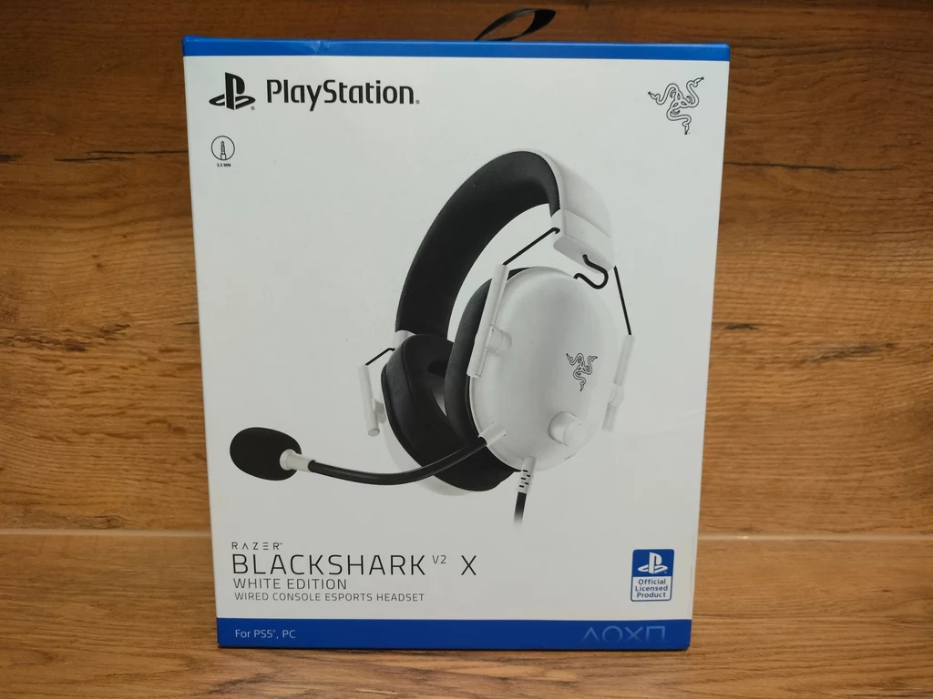 Razer BlackShark V2 X White Edition Opakowanie słuchawek gamingowych Razer BlackShark V2 X White Edition z mikrofonem, przeznaczonych do PlayStation 5 i PC, na białym tle z wyraźnym logo PlayStation i Razer.