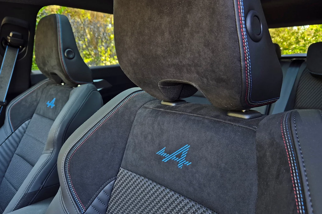 Renault Austral Czarne tapicerowane siedzenia samochodowe z wyhaftowanym niebieskim logo i kolorystycznymi akcentami, podkreślające sportowy i nowoczesny design wnętrza auta.