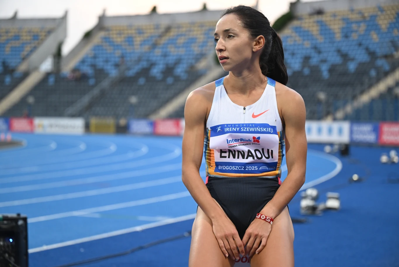 Sofia Ennaoui w Bydgoszczy Lekkoatletka w stroju sportowym stoi na bieżni stadionu lekkoatletycznego, w tle widać puste trybuny oraz elementy infrastruktury sportowej.