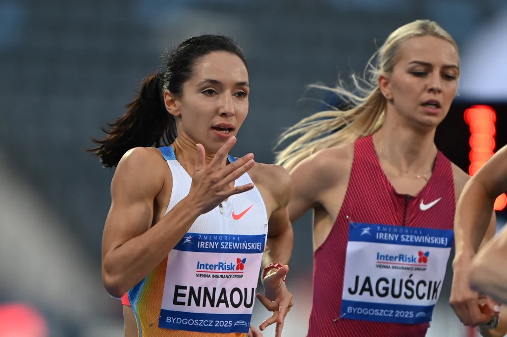 Sofia Ennaoui i Julia Jaguścik Dwie zawodniczki biegnące na stadionie lekkoatletycznym podczas zawodów, skupione na rywalizacji, widoczne numery startowe oraz nazwy wydarzenia sportowego.