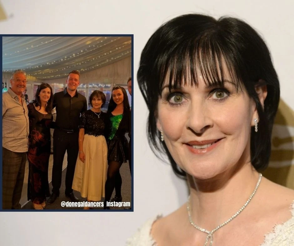 Enya pokazała się publicznie Kobieta z krótkimi ciemnymi włosami i jasną karnacją uśmiecha się delikatnie, ma na sobie jasną bluzkę i delikatny naszyjnik. W lewym górnym rogu widoczna jest mała wstawka przedstawiająca grupę pięciu osób pozujących razem pod namiotem, oświetlonym gi...