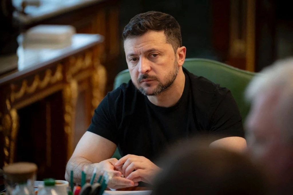 Wołodymyr Zełenski zabrał głos po wygranej Karola Nawrockiego Mężczyzna w czarnej koszulce siedzi przy bogato zdobionym stole, skupiony i zamyślony, w otoczeniu eleganckiego wnętrza z detalami ze złoceniami.
