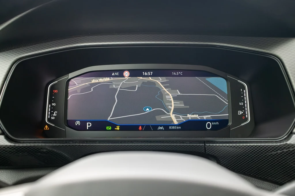 Volkswagen T-Cross Cyfrowy kokpit samochodu z wyświetlaczem prezentującym mapę nawigacji GPS, wybrane parametry jazdy oraz wskaźniki dotyczące prędkości i poziomu paliwa.
