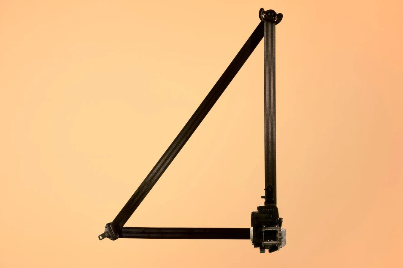 Czarny, geometryczny element konstrukcyjny w kształcie cyfry cztery na jednolitym, jasnobeżowym tle, z widocznym zawiasem i metalowym mechanizmem w dolnej części.