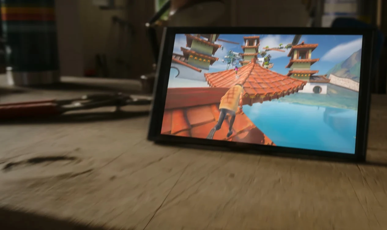 Fortnite Tablet wyświetlający dynamiczną grę wideo z postacią wspinającą się po dachu budynku otoczonego wodą oraz orientalnymi konstrukcjami na tle jasnego, kolorowego krajobrazu.