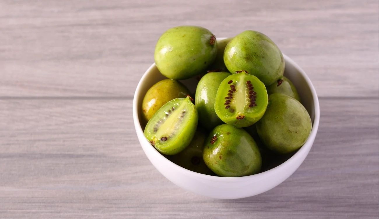 Jak sama nazwa wskazuje, minikiwi wygląda jak miniaturowy owoc kiwi, ale o gładkiej skórce /CanvaPro