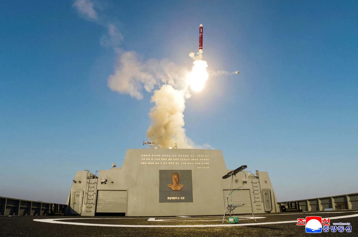 Wystrzelenie pocisku Hwasal-2 z fregaty Choi-Hyun Rakieta startuje w górę z pokładu okrętu wojskowego, unosząc się w kłębach dymu na tle czystego, niebieskiego nieba, wokół widoczne są elementy techniczne okrętu.