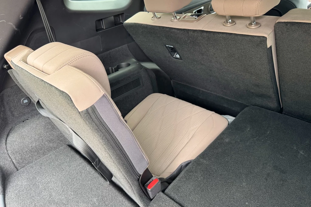 Chery Tiggo 8 sprzedawane będzie w wersji 7-miejscowej – z dwoma fotelami w podłodze bagażnika Tylne siedzenia samochodu z jednym fotelem rozłożonym do pozycji siedzącej, widoczne elementy tapicerki w jasnym kolorze oraz przestrzeń bagażowa.