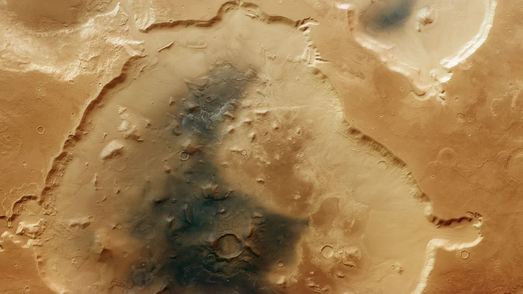 Krater Deuteronilus Cavus na obrazie z sondy Mars Express agencji ESA. Rozległy krater z widocznymi strukturami powierzchni i cieniami, charakterystyczne ciepłe barwy typowe dla powierzchni Marsa oraz liczne mniejsze kratery i bruzdy w obrębie formacji.