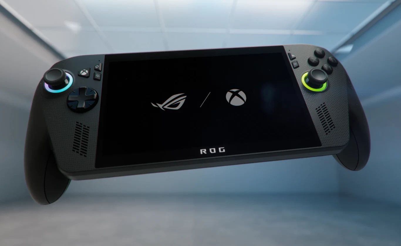 ROG Xbox Ally Konsola do gier typu handheld z wyświetlaczem, na ekranie widoczne logotypy ROG oraz Xbox, po bokach ekranu znajdują się joysticki, przyciski i głośniki, całość utrzymana w nowoczesnym, minimalistycznym otoczeniu.