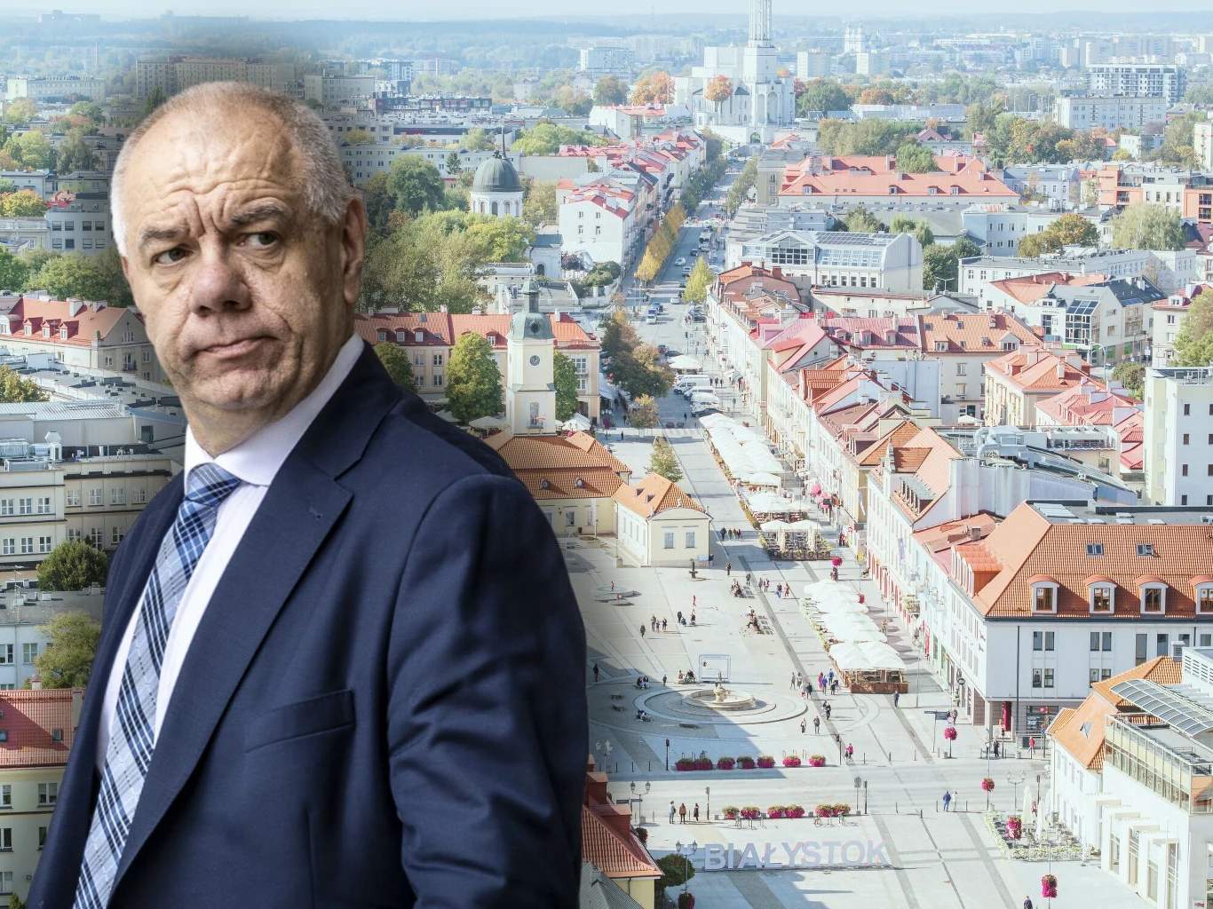 Jacek Sasin zapowiada referendum ws. odwołania władz sejmiku województwa podlaskiego Mężczyzna w garniturze na tle panoramy miejskiej z charakterystycznymi, czerwonymi dachami kamienic oraz szeroką ulicą zabudowaną po obu stronach, wskazującą na centrum miasta.