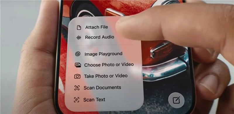 Palec dotykający ekran smartfona z wyświetlonym menu opcji, w tle fragment kolorowej grafiki przedstawiającej samochód.