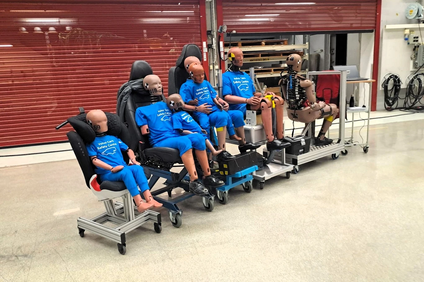 manekiny w niebieskich koszulkach Volvo Cars Safety Centre siedzą w fotelikach samochodowych i na siedzeniach