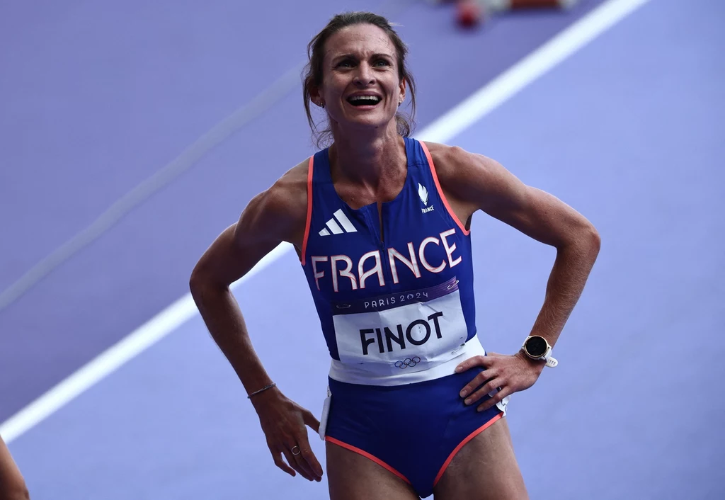 Alice Finot po swoim rekordowym biegu w Paryżu Christelle Finot, francuska biegaczka, uśmiecha się po biegu. Ma na sobie niebieski strój z napisem "France" i różowymi lamówkami. Na nadgarstku ma zegarek.