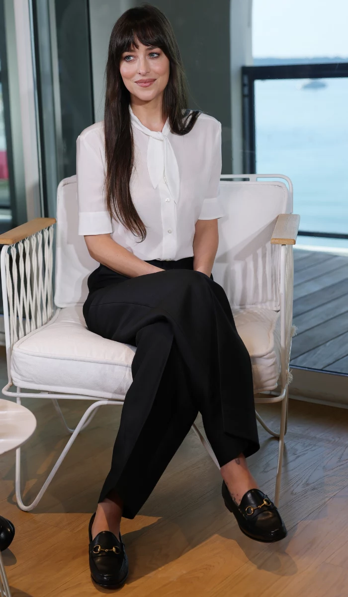 Dakota Johnson w klasycznej koszuli i prostych spodniach podczas wywiadu w Cannes