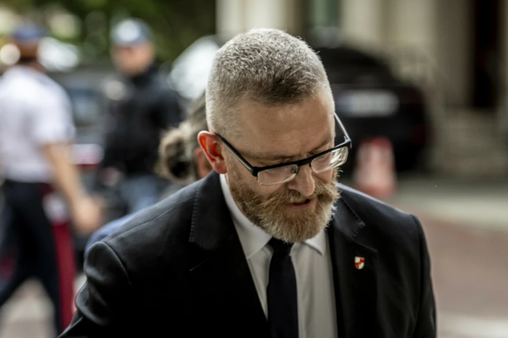 Grzegorz Braun opuszczający Sejm po zniszczeniu wystawy